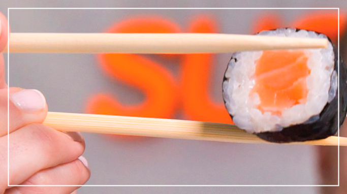 Lækker sushirulle fra Sushi Mania mellem to spisepinde